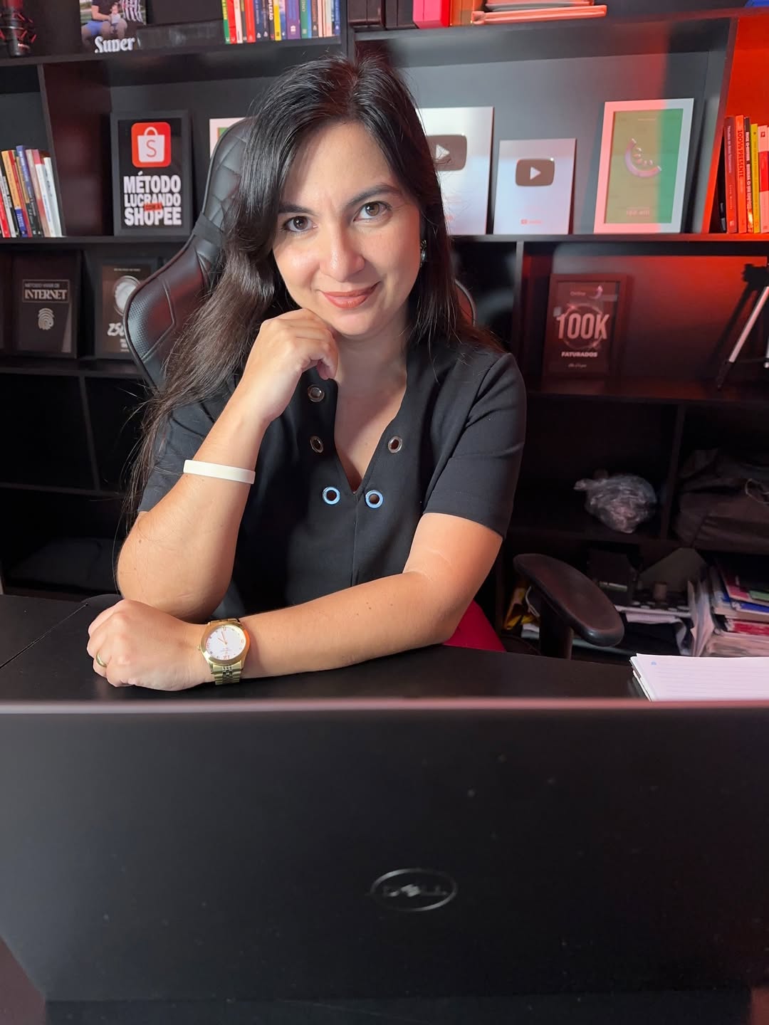 Jacqueline Coelho sentada em frente a uma mesa de trabalho
