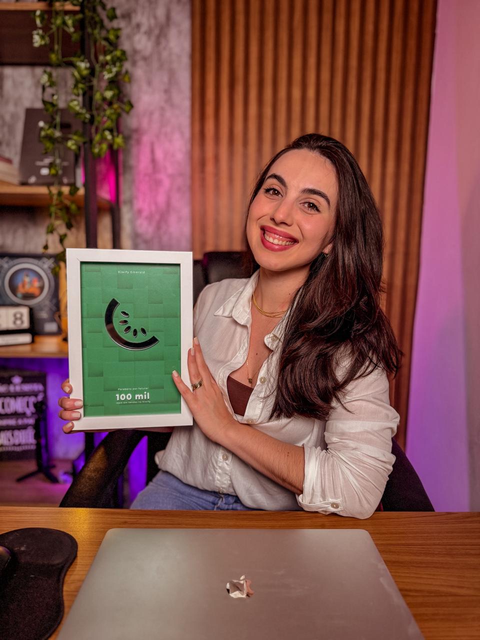 Mayara Prado sorrindo em um ambiente de trabalho